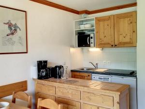 a kitchen with a counter top and a stove top oven at Appartement 2 pièces cosy aux Menuires, balcon sud-ouest, pied des pistes, proche commodités - FR-1-178-377 in Les Bruyères