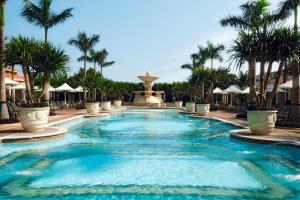 uma piscina num resort com palmeiras e uma fonte em The Venetian Macao em Macau