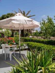 een tafel en stoelen onder een parasol op een patio bij Vicky Studios and Apartments in Skala Kallonis