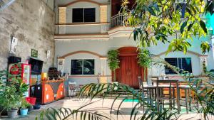 una habitación con mesa y sillas y un edificio en La maison de Soriya - Work & Stay en Kampot