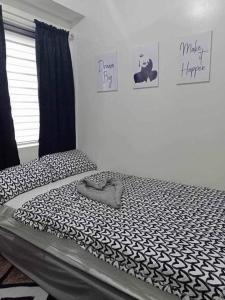 una camera da letto con un letto con un piumone bianco e nero di Chelsea Suite's Esthetic Staycation at Trees Residence QC a Manila