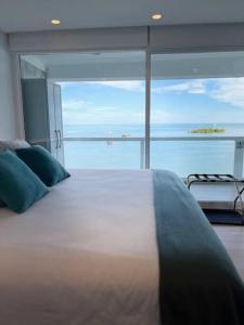 Ένα ή περισσότερα κρεβάτια σε δωμάτιο στο Lujoso apto con balcón, vista al mar y playa privada