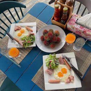 a table with two plates of breakfast food on it at คุ้มกะลาหัวฟาร์มสเตย์ (Khumkalahua Farmstay) in Ban Pha Saeng Lang