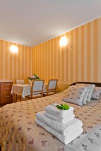 a hotel room with a bed with towels on it at Vila Vika in Palanga