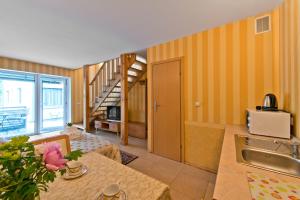 a kitchen with a table and a sink and a staircase at Vila Vika in Palanga