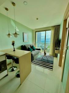 a living room with a couch and a table at The Riviera Jomtien one bedroom in Jomtien Beach