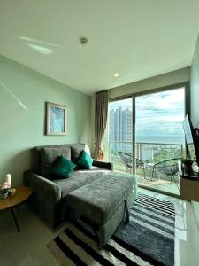 a living room with a couch and a large window at The Riviera Jomtien one bedroom in Jomtien Beach