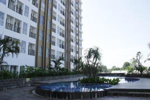 un bâtiment avec deux fontaines en face d'un bâtiment dans l'établissement Apartemen Skylounge Makassar, à Makassar