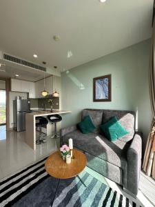 un soggiorno con divano e tavolo di The Riviera Jomtien one bedroom a Jomtien Beach