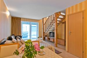 a living room with a couch and a table with flowers at Vila Vika in Palanga