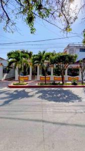 a building with palm trees in front of a street at Casa Blanca María Barranquilla - Authentic colonial house in Barranquilla