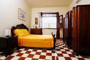 a bedroom with a bed and a checkered floor at Casa Blanca María Barranquilla - Authentic colonial house in Barranquilla