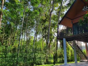 a house with a balcony in front of trees at บ้านสวนเรินย่า(เรินย่าคาเฟ่) in Thung Song