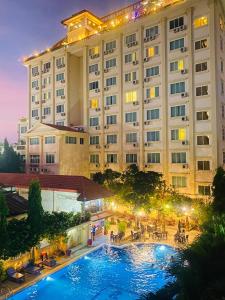 a hotel with a swimming pool in front of a building at Classy Hotel in Battambang