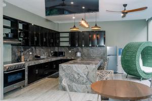 a kitchen with black cabinets and a table in it at Casa Ferta in Pansol