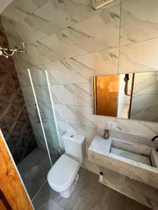 a bathroom with a toilet and a sink at casa de temporada Gabyviti in Sao Paulo