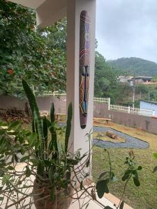a surfboard on the side of a porch with a plant at Hostel Portal da Montanha in Blumenau