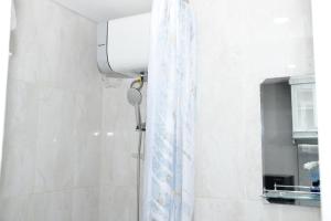 a shower curtain in a bathroom next to a window at Apartemen Skylounge Makassar in Makassar