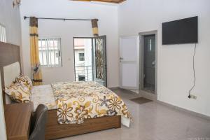 1 dormitorio con 1 cama y TV en Longho Lodge Bundoma - Buea en Buea