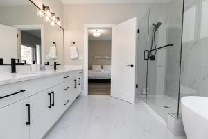 a white bathroom with a shower and a sink at Luxurious Home in Lake Cowichan in Lake Cowichan