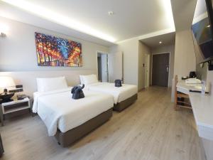 una camera d'albergo con due letti e un dipinto sul muro di Le Naview @Prasingh a Chiang Mai