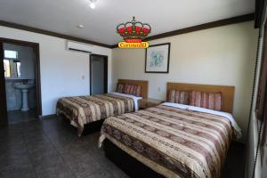 Habitación de hotel con 2 camas y lámpara de araña. en Hotel Coronado, en Ensenada