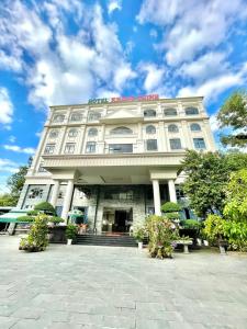 um edifício branco com uma placa em cima em Khang Thịnh Hotel Long Thành em Long Thành