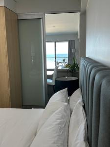 a bedroom with a bed and a view of the ocean at Absolute Beachfront at the Pier Glenelg in Adelaide