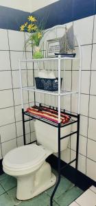 a bathroom with a white toilet and a shelf at Relax at Pier Sands Casita#1 - Close to the Beach! in Puntarenas