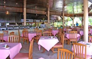 a restaurant with tables and chairs with pink table cloth at Phuket Golden Sand Inn - SHA Extra Plus in Karon Beach