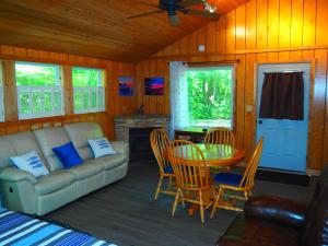 a living room with a couch and a table and chairs at Cavalier Cottage - Private Lakefront w Kayaks! in Honor