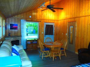 a living room with a couch and a table and chairs at Cavalier Cottage - Private Lakefront w Kayaks! in Honor