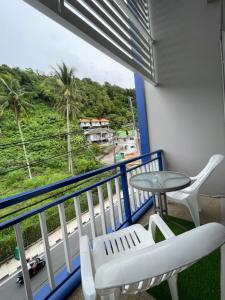 a balcony with a table and chairs and a view at Kata Sea Blue in Kata Beach