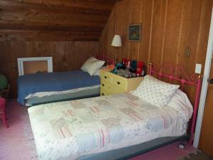 a bedroom with two beds and a table with a lamp at Sunset Serenity - Incredible Home On Lake Bluff! in Frankfort