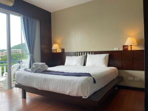 a bedroom with a bed with a teddy bear on it at Kata Sea Blue in Kata Beach