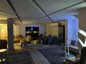sala de estar con sofá y mesa en Trio villa with falls in compound فلا بحديقة كبيره وشلالات صناعية en Sheikh Zayed