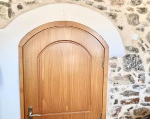 uma porta de madeira num quarto com uma parede de pedra em Μεσαιωνικό σπιτι. em Mestá