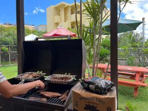 a man is cooking food on a grill at 北谷 vacation house MALAPUA in Chatan