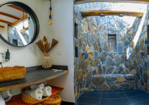 a bathroom with a shower with a stone wall at Asis Glamping 1 in Guatapé