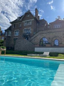 a large house with a swimming pool in front of it at Le loft du Castel Mosan in Namur