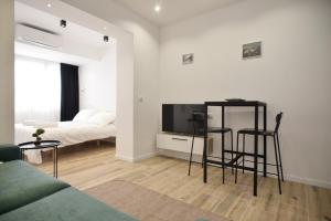 a living room with a couch and a tv and a bed at Tirana Central Apartments in Tirana