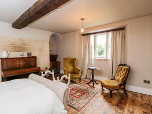 ein Schlafzimmer mit einem Bett, einem Klavier und Stühlen in der Unterkunft Reybridge House in Chippenham