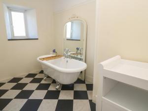 a white bathroom with a tub and a sink at Penmarth House in Helston