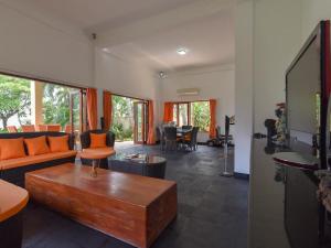 ein Wohnzimmer mit einem Sofa und einem Tisch in der Unterkunft Villa Singkenken in Kubutambahan