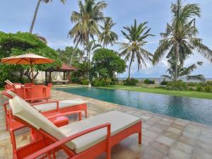 ein Resort mit einem Pool mit Stühlen und einem Sonnenschirm in der Unterkunft Villa Singkenken in Kubutambahan