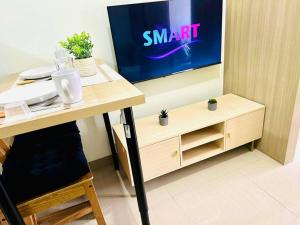 a room with a desk with a tv on a wall at Simple but cozy 1BR Shore 2 MOA in Manila