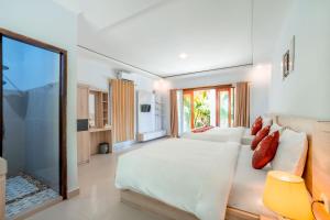 ein Schlafzimmer mit einem großen Bett und einem großen Fenster in der Unterkunft Kalpataru Cottage in Nusa Penida