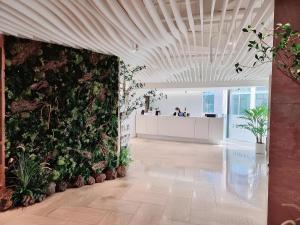 an office lobby with a green wall with plants at New Seoul Hotel Myeongdong in Seoul