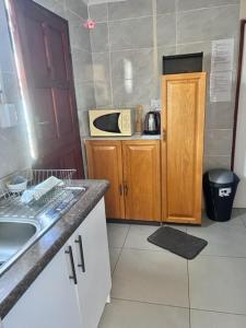 a small kitchen with a sink and a microwave at MaU Bed and Breakfast in Krugersdorp