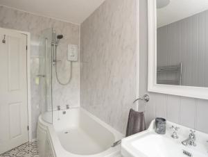 ein Badezimmer mit Waschbecken, Badewanne und Toilette in der Unterkunft Frongoch Cottage in Pentraeth + 30 Fotos